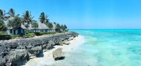 rocky beach with white cottages under clear blue sky